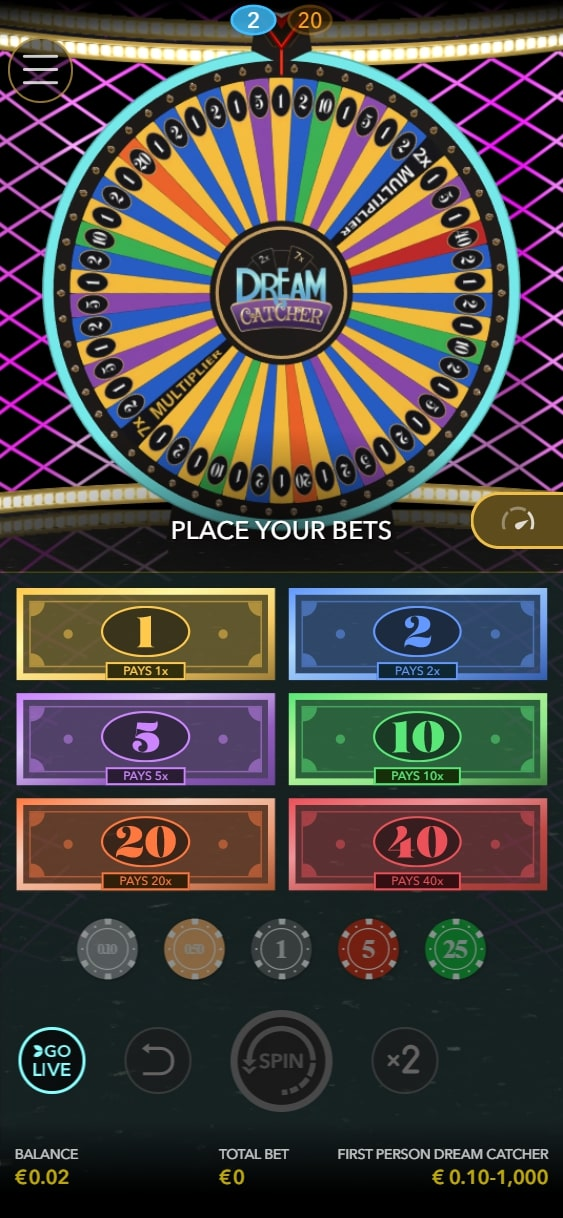 Esta imagen muestra una interfaz de juego de casino digital llamada "Dream Catcher". La característica principal es una rueda grande y colorida dividida en segmentos numerados, que recuerda a una rueda de premios. La rueda tiene un vibrante esquema de colores arcoíris con números que van del 1 al 40.